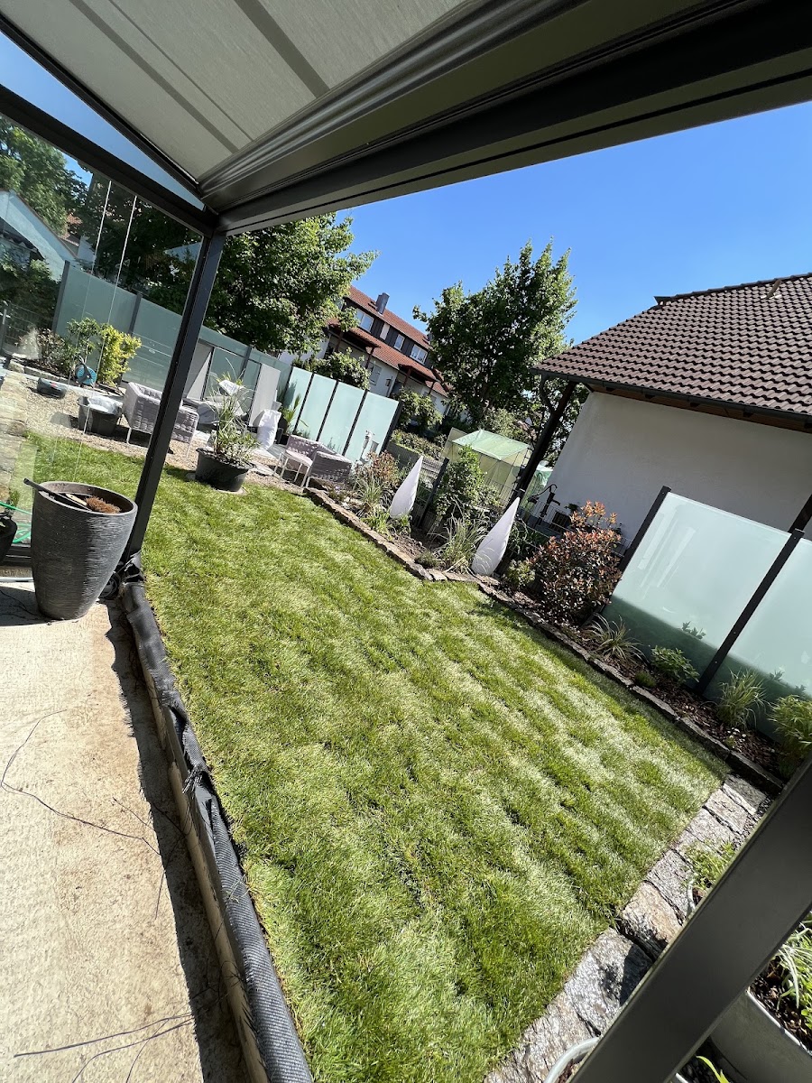 Terrassenüberdachung mit frisch angelegter Rasenfläche